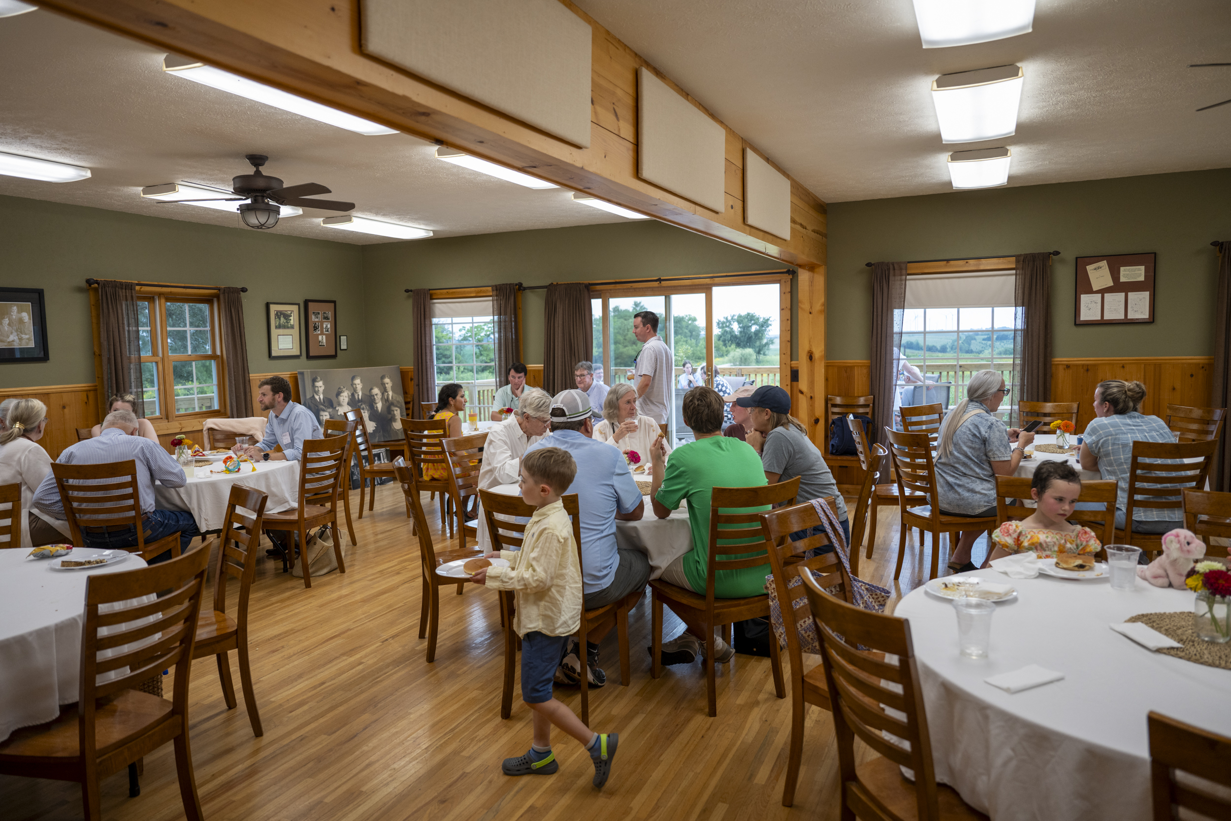 group of people sitting inside gathering barn room